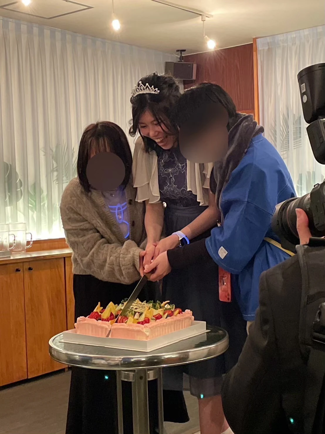 ケーキ入刀でお祝いする参加者