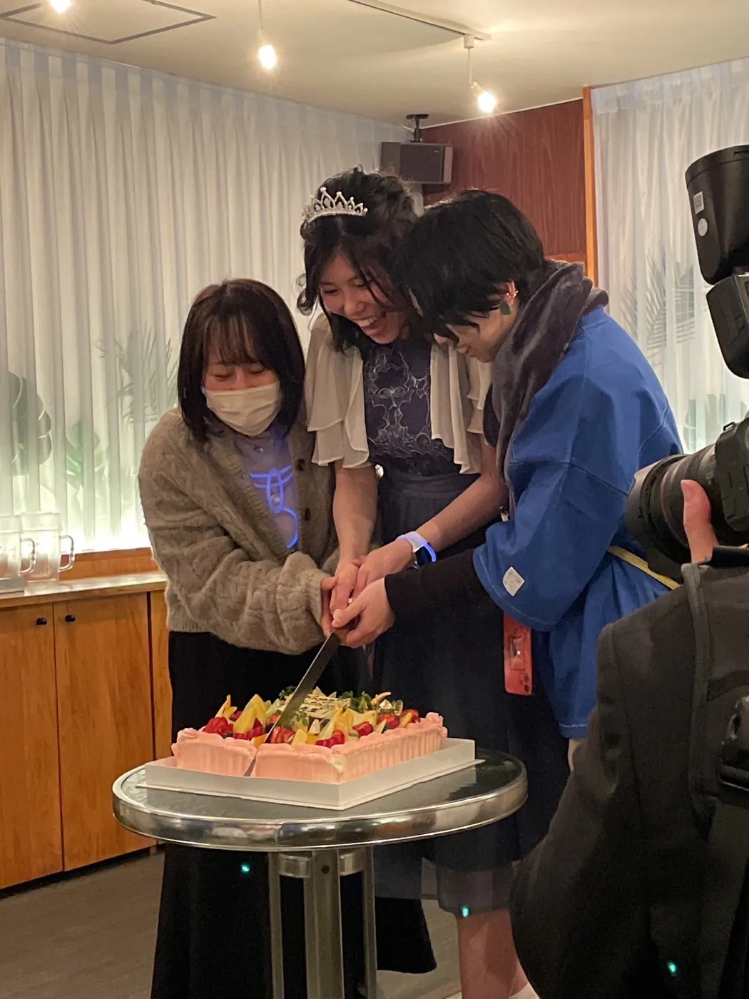 ケーキ入刀でお祝いする参加者